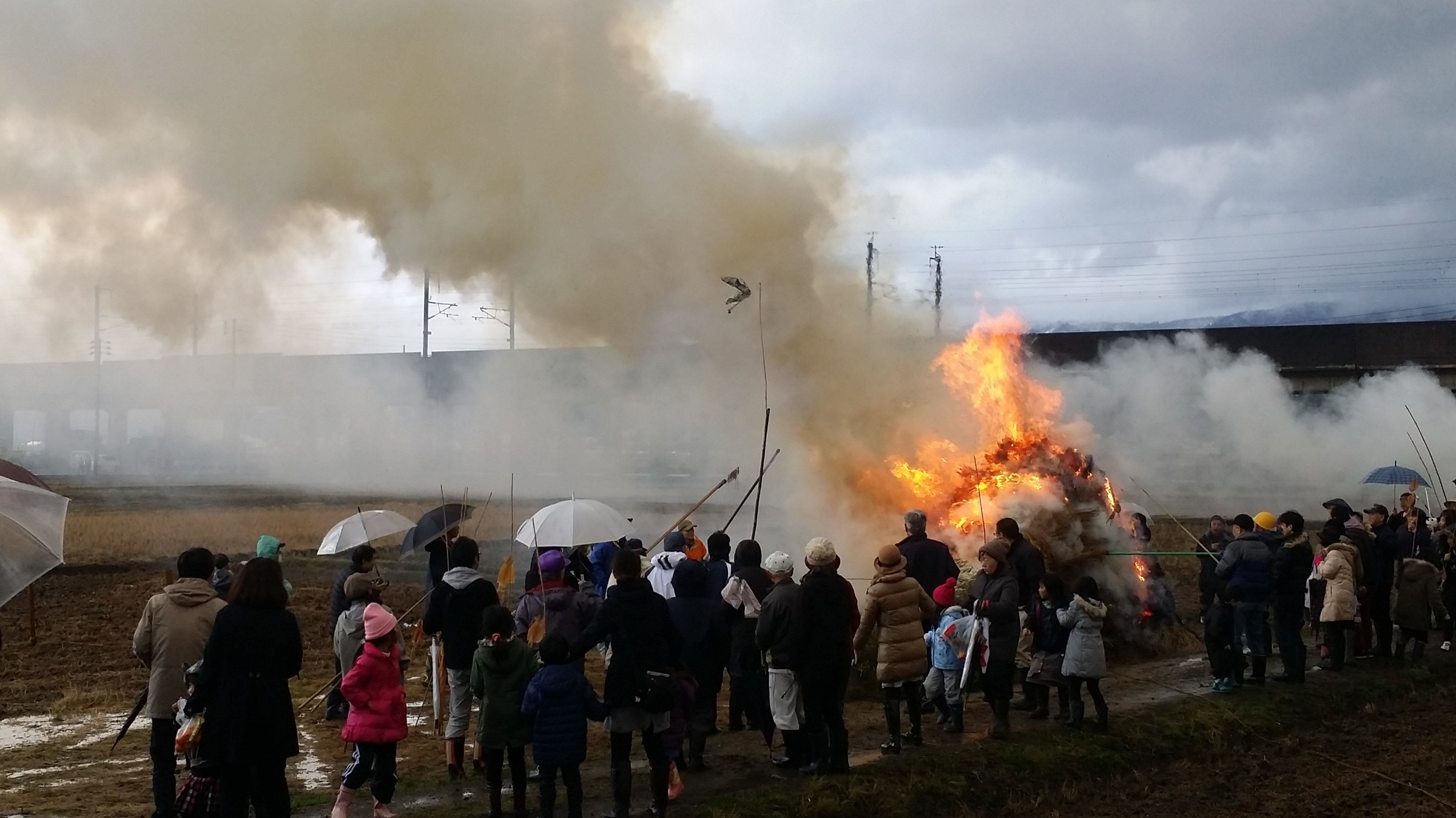 Dopo il crollo del cono, la gente tiene lunghe canne di bambù nel fuoco