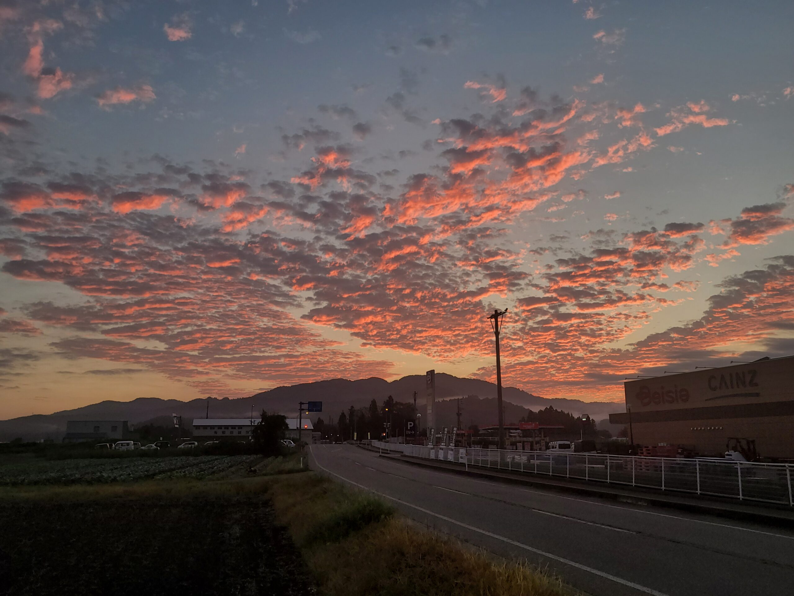 Morgenrot über Feldern und Bergen