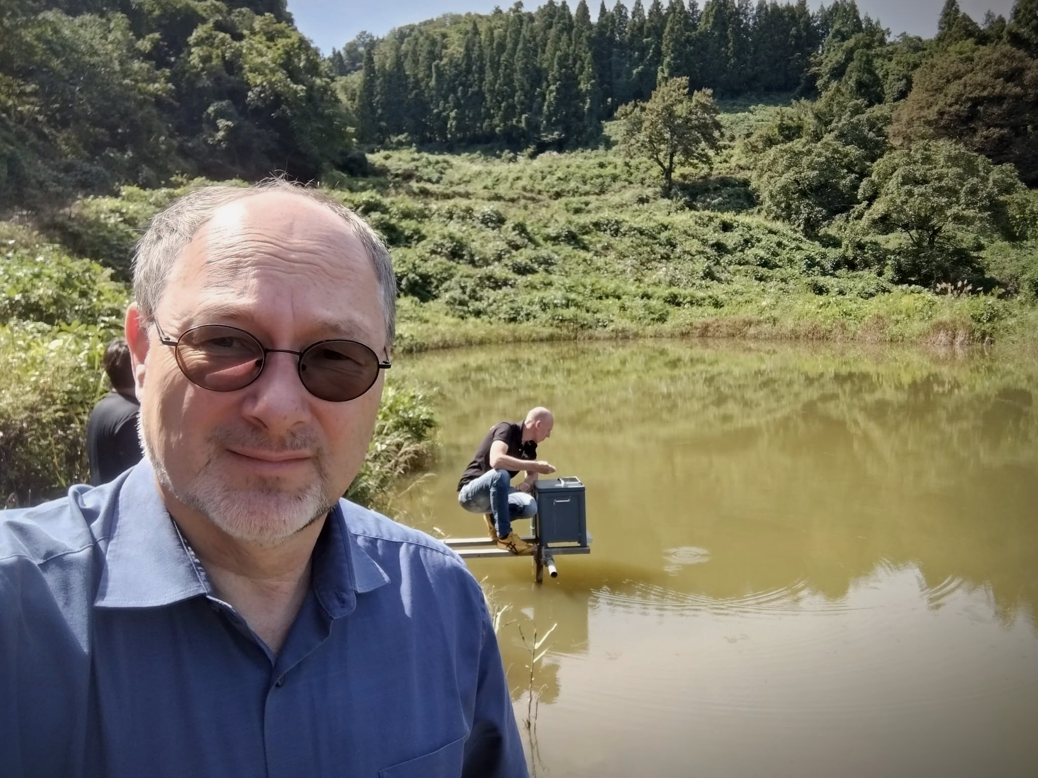 Harry Palm vorne, im Hintergrund Harald Bachmann auf einem Steg am Teich